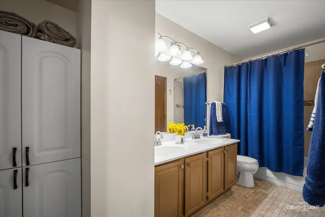 a bathroom with a double vanity sink toilet and shower