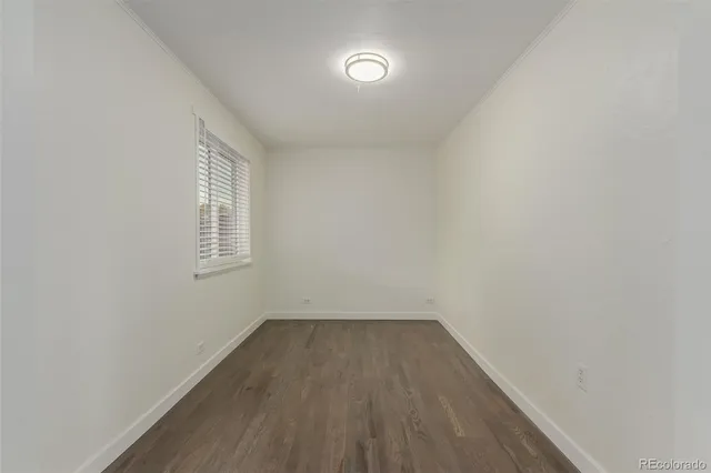 a view of a room that has wooden floor and window
