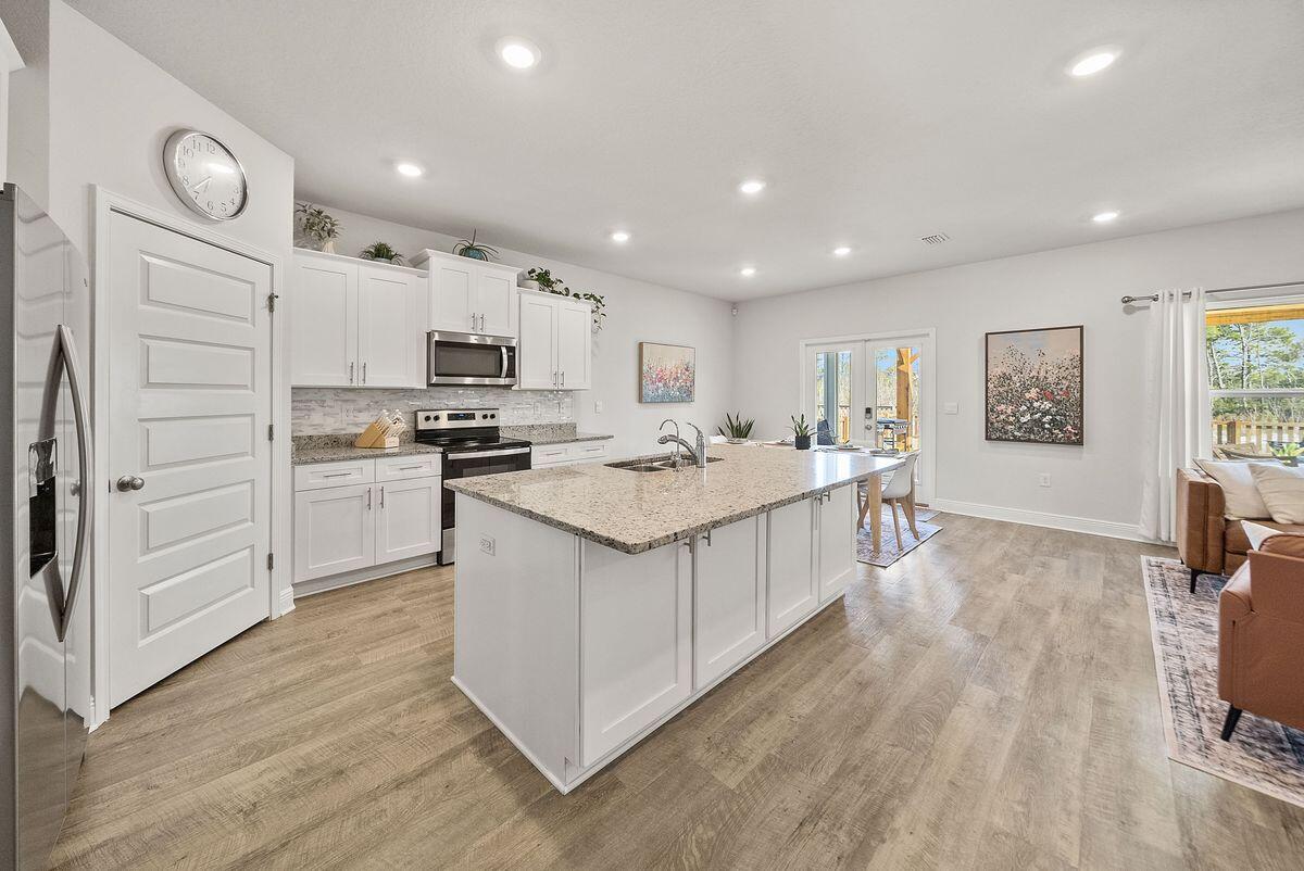 774 Backwater Road Port St. Joe, FL 32456 - Photo 11 of 65 a kitchen with white cabinets and stainless steel appliances