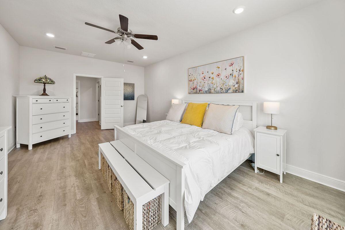 774 Backwater Road Port St. Joe, FL 32456 - Photo 20 of 65 a spacious bedroom with a bed and a chandelier