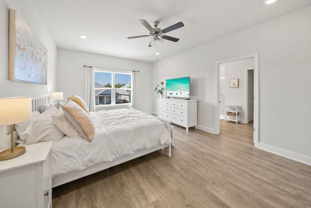 774 Backwater Road Port St. Joe, FL 32456 - Photo 22 of 65 a spacious bedroom with a bed and a chandelier