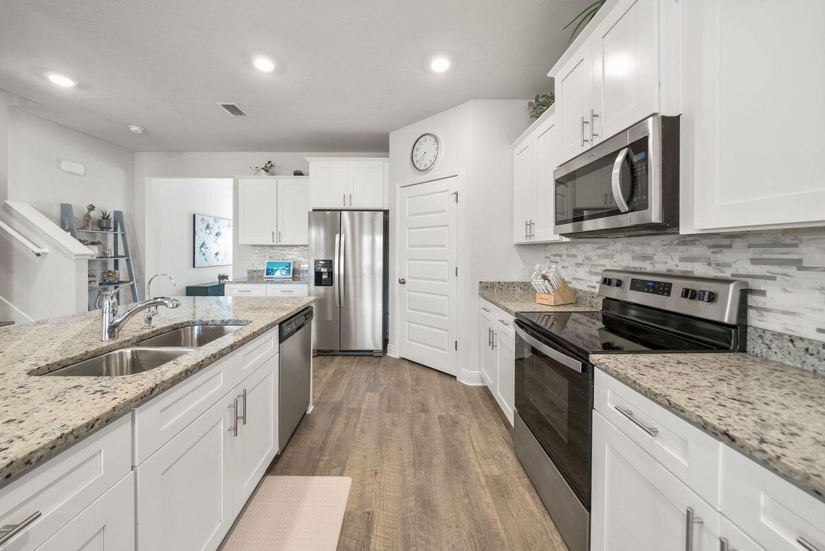 774 Backwater Road Port St. Joe, FL 32456 - Photo 9 of 65 a kitchen with stainless steel appliances granite countertop a sink stove and refrigerator