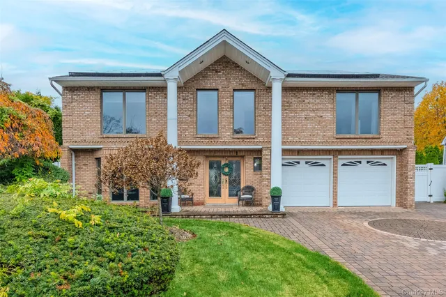 front view of a brick house with a yard