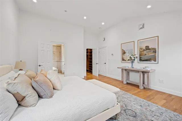 a bedroom with a large bed and a wooden floor