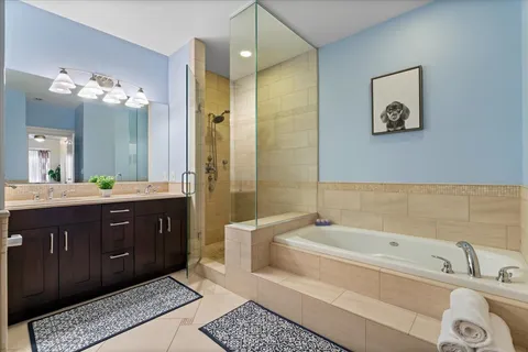 a spacious bathroom with a tub sink and mirror