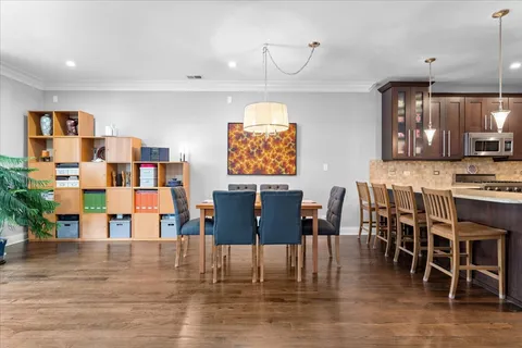 a view of kitchen with stainless steel appliances granite countertop a dining table chairs and granite counter tops