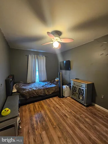 a bedroom with bed and wooden floor