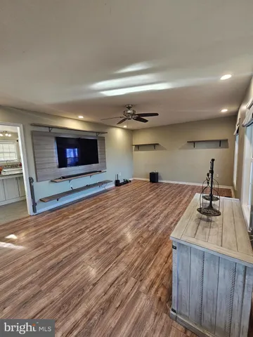 a room with wooden floor and flat screen tv