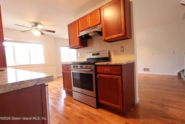 a kitchen with stainless steel appliances granite countertop a stove a sink and a microwave