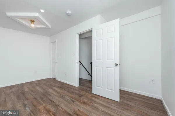 an empty room with wooden floor and entryway