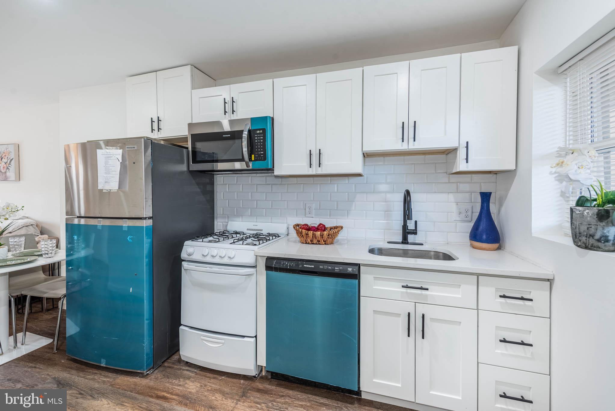 554 Gold Street Baltimore, MD 21217 - Photo 7 of 23 a kitchen with white cabinets and stainless steel appliances