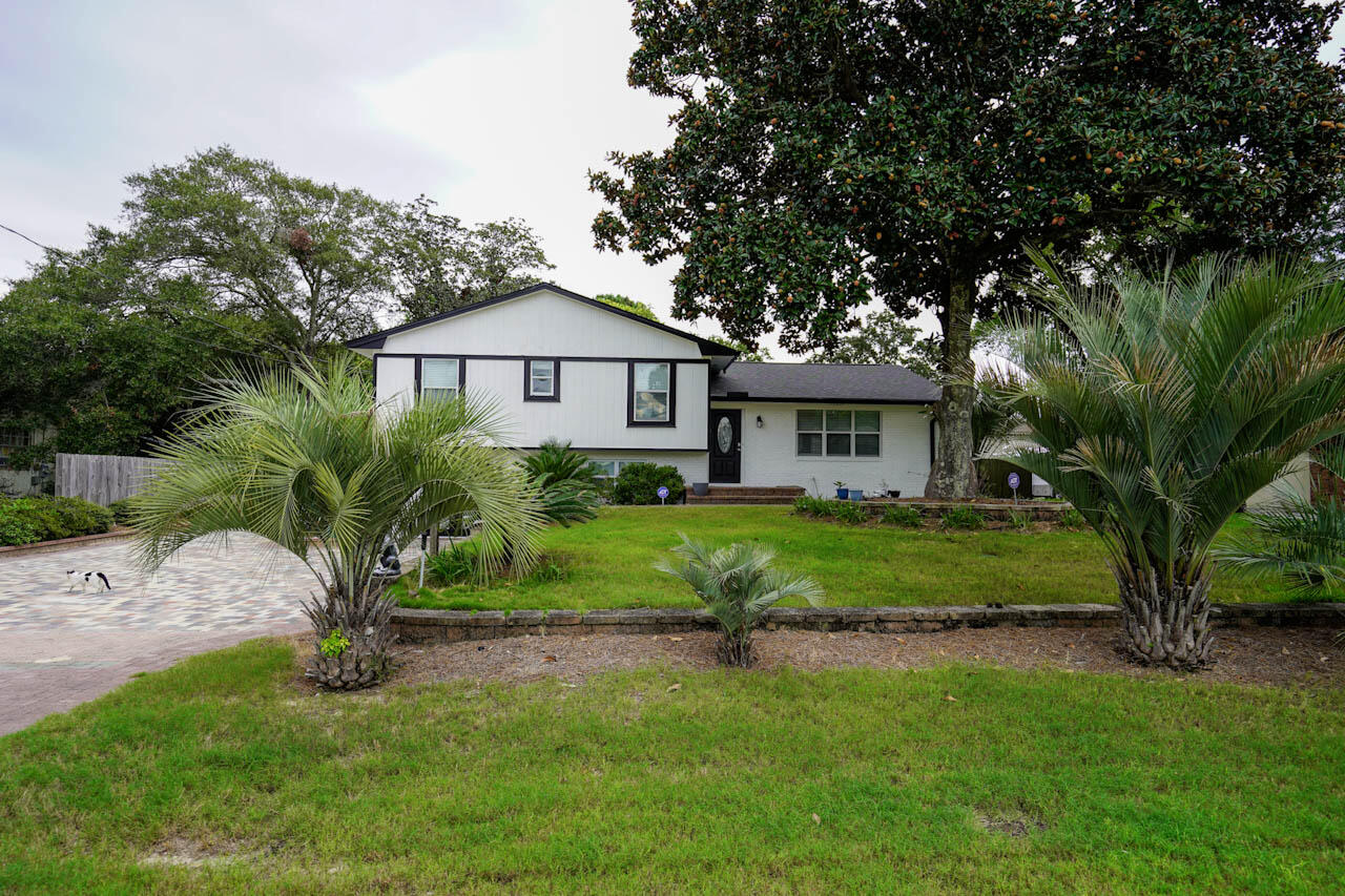536 Benning Drive Destin, FL 32541 - Photo 2 of 46 a front view of a house with a garden and yard
