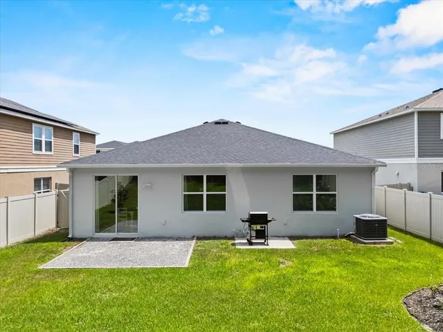 a backyard of a house with table and chairs
