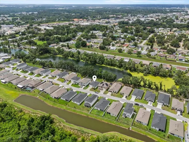 an aerial view of residential houses with outdoor space and lake view