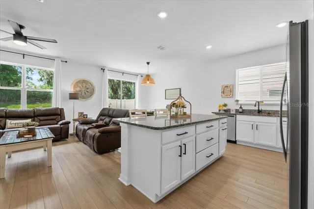 a kitchen with stainless steel appliances granite countertop a refrigerator a stove and a sink with dishwasher