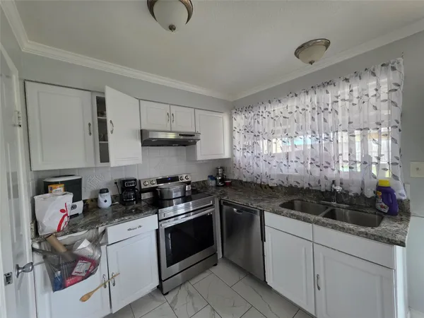 a kitchen with stainless steel appliances granite countertop a sink stove and cabinets