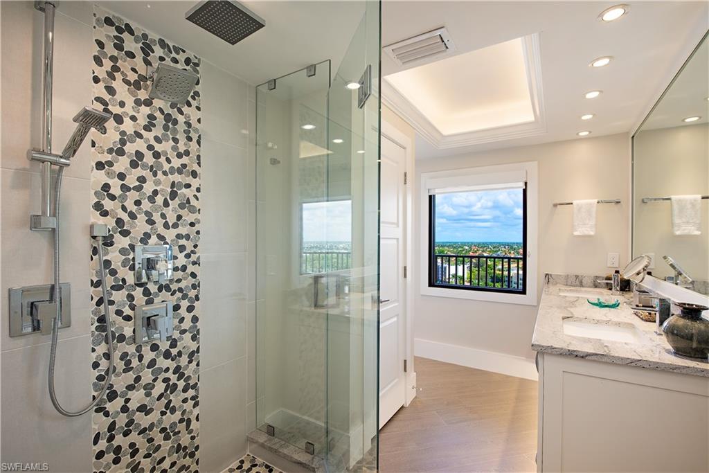 850 South Collier Boulevard, Unit 1103 Marco Island, FL 34145 - Photo 10 of 24 a bathroom with a shower sink and mirror