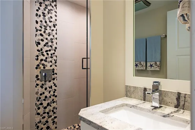 a bathroom with a sink a mirror and a shower