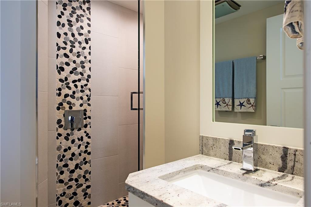 850 South Collier Boulevard, Unit 1103 Marco Island, FL 34145 - Photo 13 of 24 a bathroom with a sink a mirror and a shower