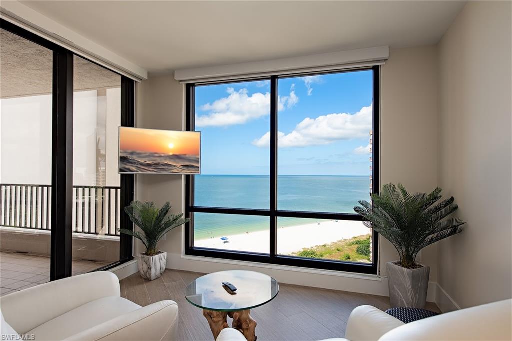 850 South Collier Boulevard, Unit 1103 Marco Island, FL 34145 - Photo 4 of 24 a living room with furniture and a floor to ceiling window