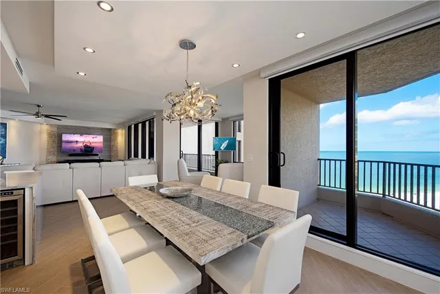 a view of a dining room with furniture a chandelier and wooden floor