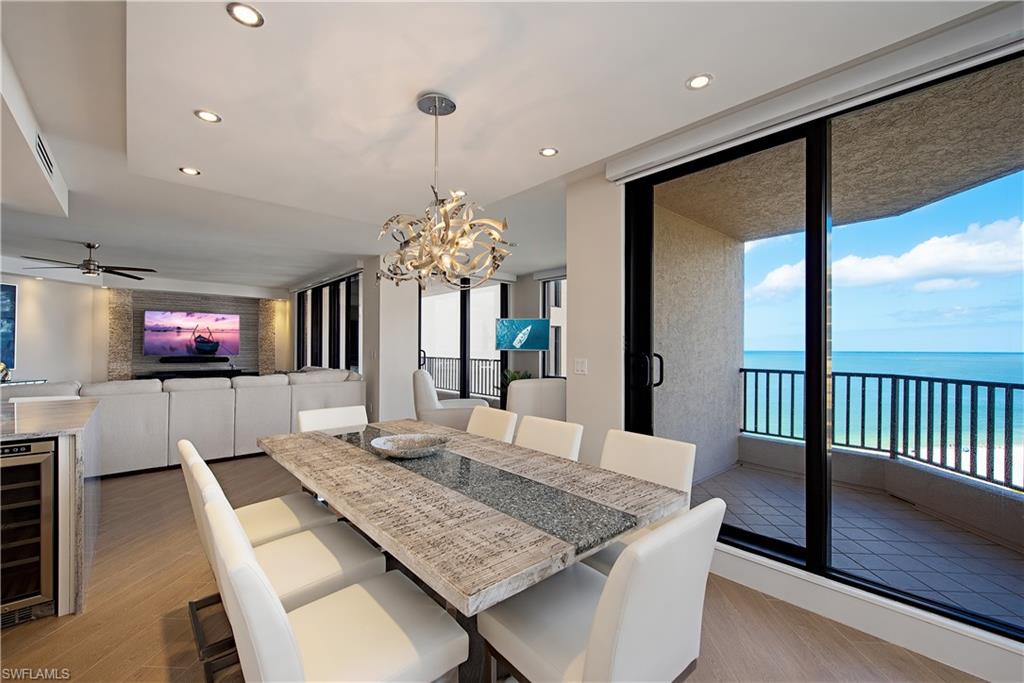 850 South Collier Boulevard, Unit 1103 Marco Island, FL 34145 - Photo 7 of 24 a view of a dining room with furniture a chandelier and wooden floor
