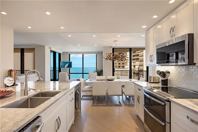 a large kitchen with granite countertop a large counter top appliances and cabinets