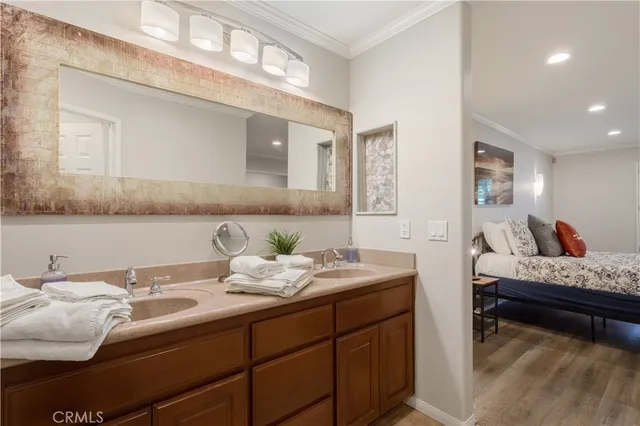 a en suite bathroom with a granite countertop sink and a mirror