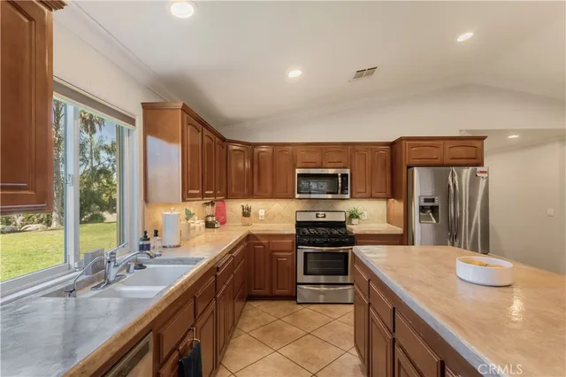 a kitchen with stainless steel appliances a sink a stove and a refrigerator