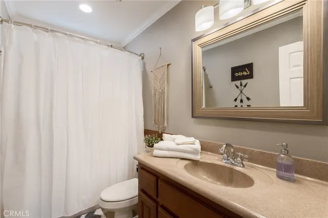 a bathroom with a granite countertop sink a toilet and a mirror