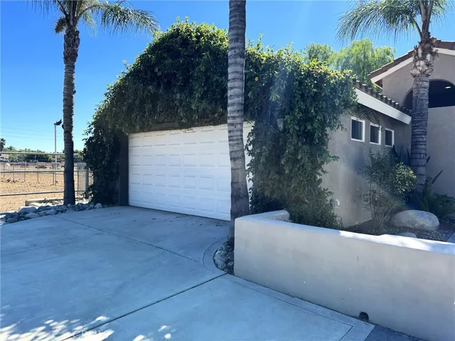 a view of a house with a yard and potted plants