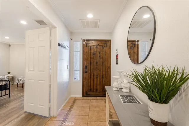 a view of a hallway with wooden floor and a potted plant