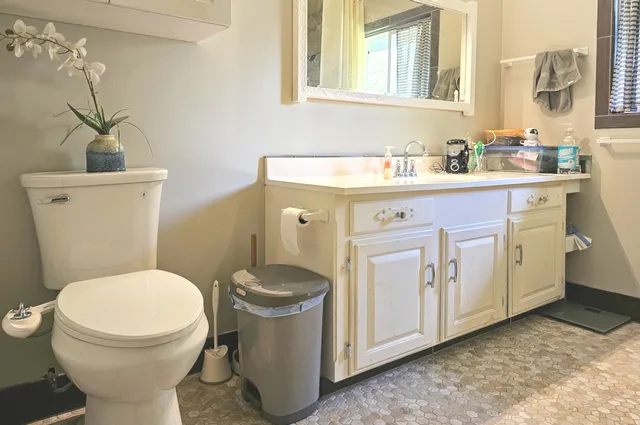 a bathroom with a toilet sink and mirror
