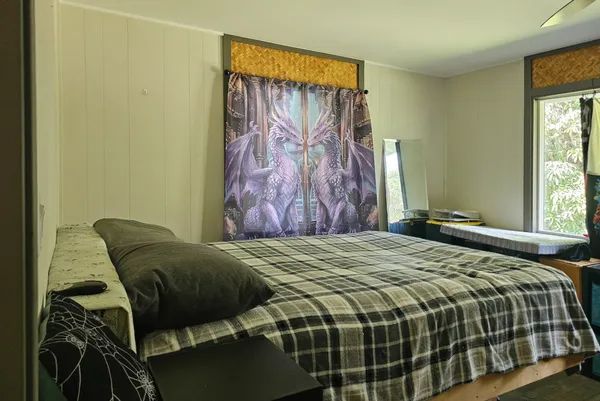 a bed sitting in a bedroom next to a window