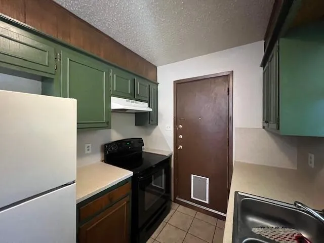 a kitchen with a refrigerator and a stove