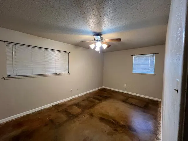 a view of an empty room with a chandelier fan