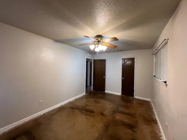 a view of an empty room with a chandelier fan