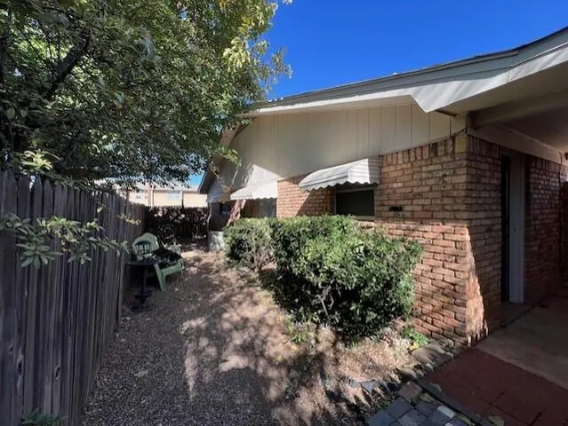 a view of backyard with potted plants and a bench