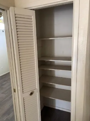 a view of walk in closet with empty racks