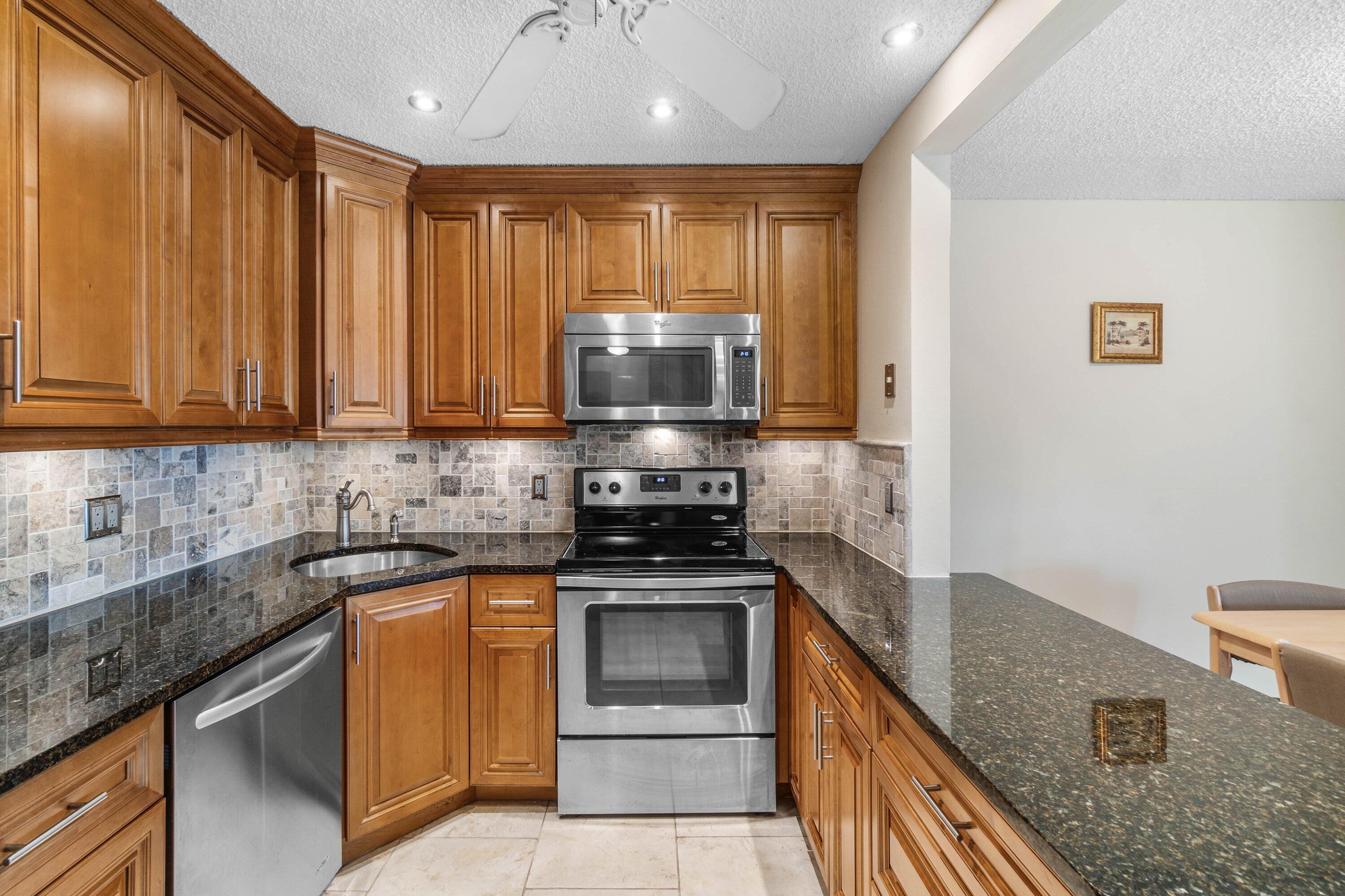 322 Pine Ridge Circle, Unit A2 Greenacres, FL 33463 - Photo 12 of 26 a kitchen with a stove microwave and sink