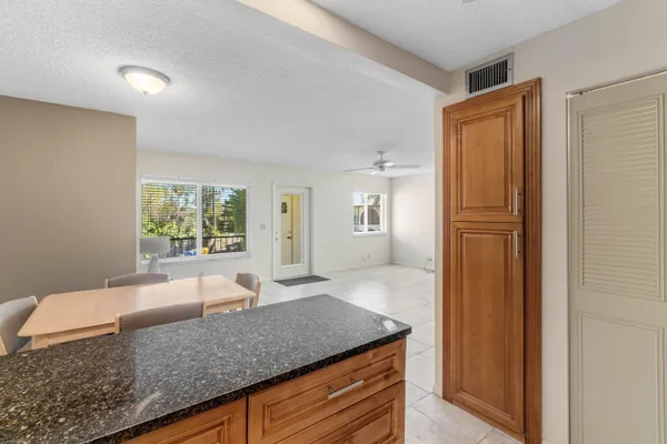 a kitchen with granite countertop a refrigerator and a stove top oven
