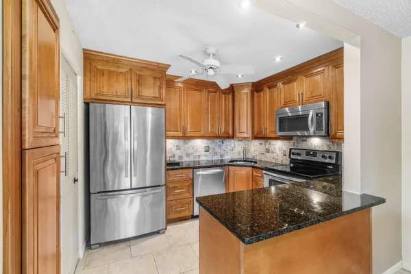 a kitchen with stainless steel appliances white cabinets and a stove top oven