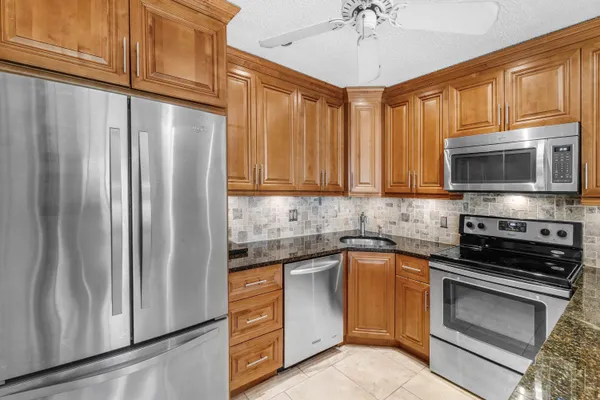 a kitchen with stainless steel appliances granite countertop a stove a sink dishwasher and a microwave oven with cabinets
