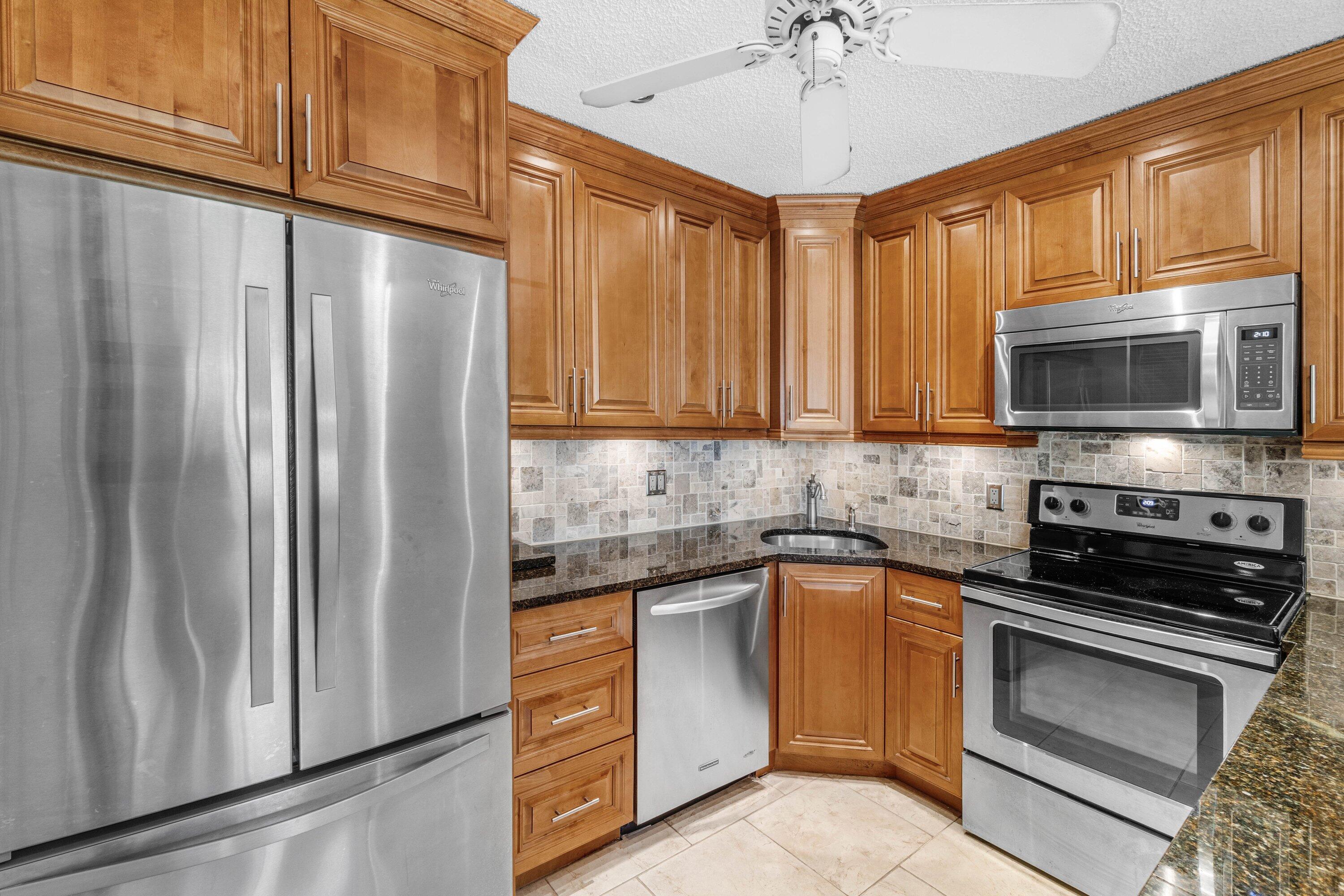 322 Pine Ridge Circle, Unit A2 Greenacres, FL 33463 - Photo 10 of 26 a kitchen with stainless steel appliances white cabinets and a stove top oven