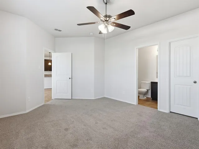 an empty room with closet and a ceiling fan