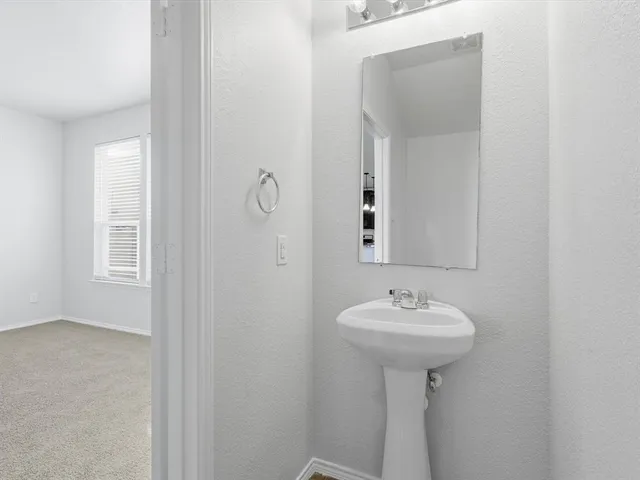 a bathroom with a sink a mirror and a window