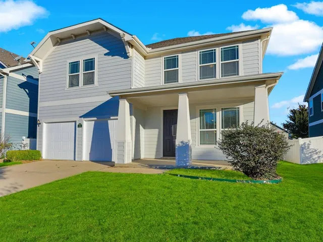 a front view of a house with garden and yard
