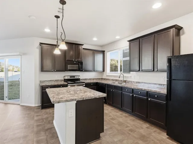 a open kitchen with stainless steel appliances granite countertop a sink stove and refrigerator