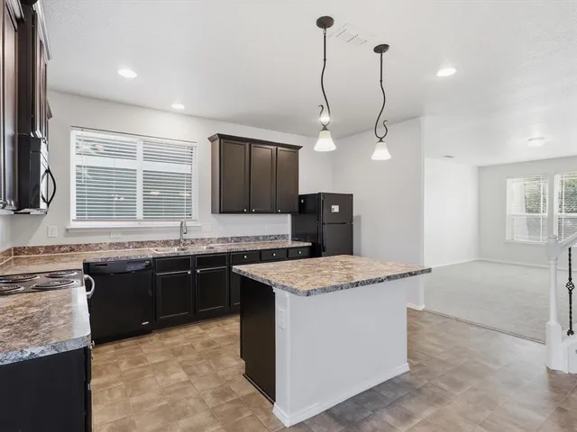 a kitchen with stainless steel appliances granite countertop cabinets sink and a stove