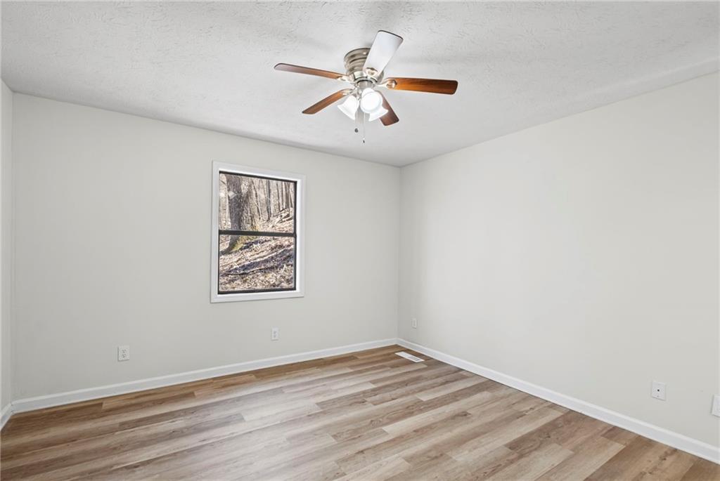 764 Chestnut Cove Trail Jasper, GA 30143 - Photo 25 of 44 an empty room with wooden floor and ceiling fan
